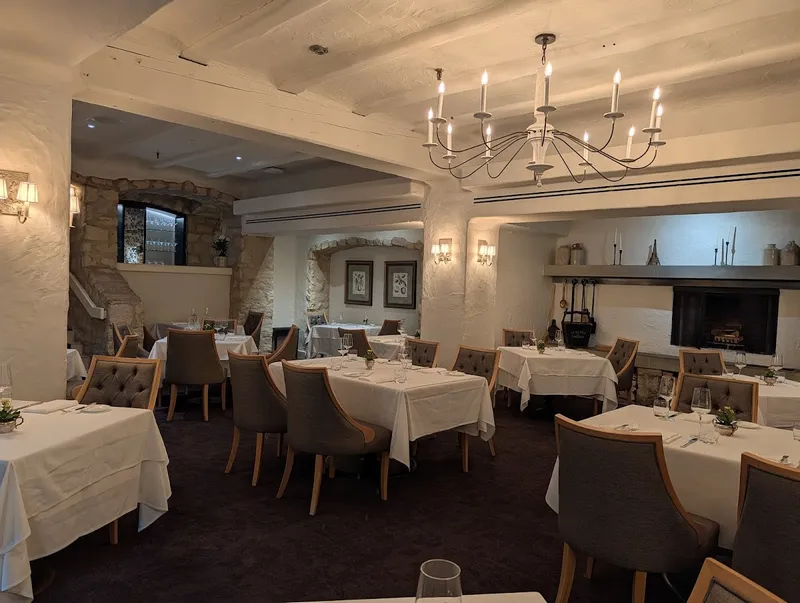 Auberge du Pommier elegant dining room with stone walls and chandelier