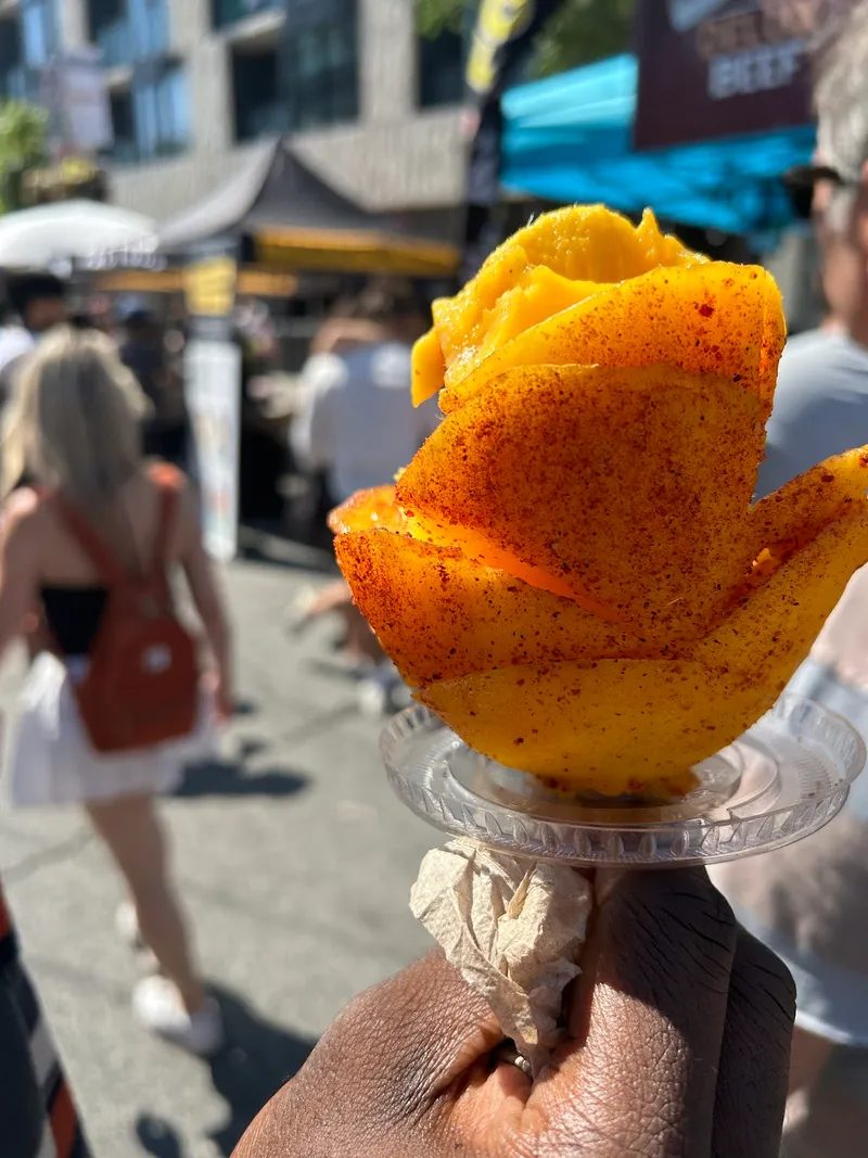 Street-festival crowd and fresh mango snack at the TD Salsa in Toronto Festival on St. Clair West