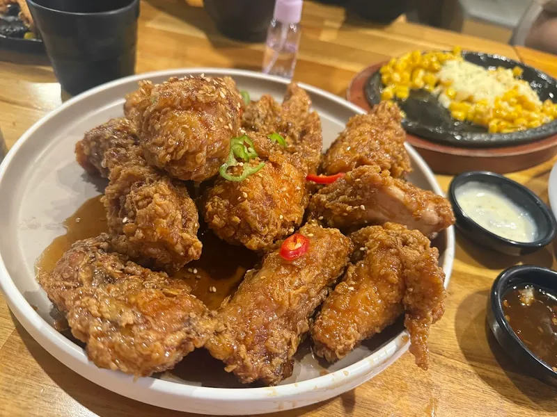 The Fry Korean fried chicken wings in glossy sauce with green onion at 4864 Yonge St North York