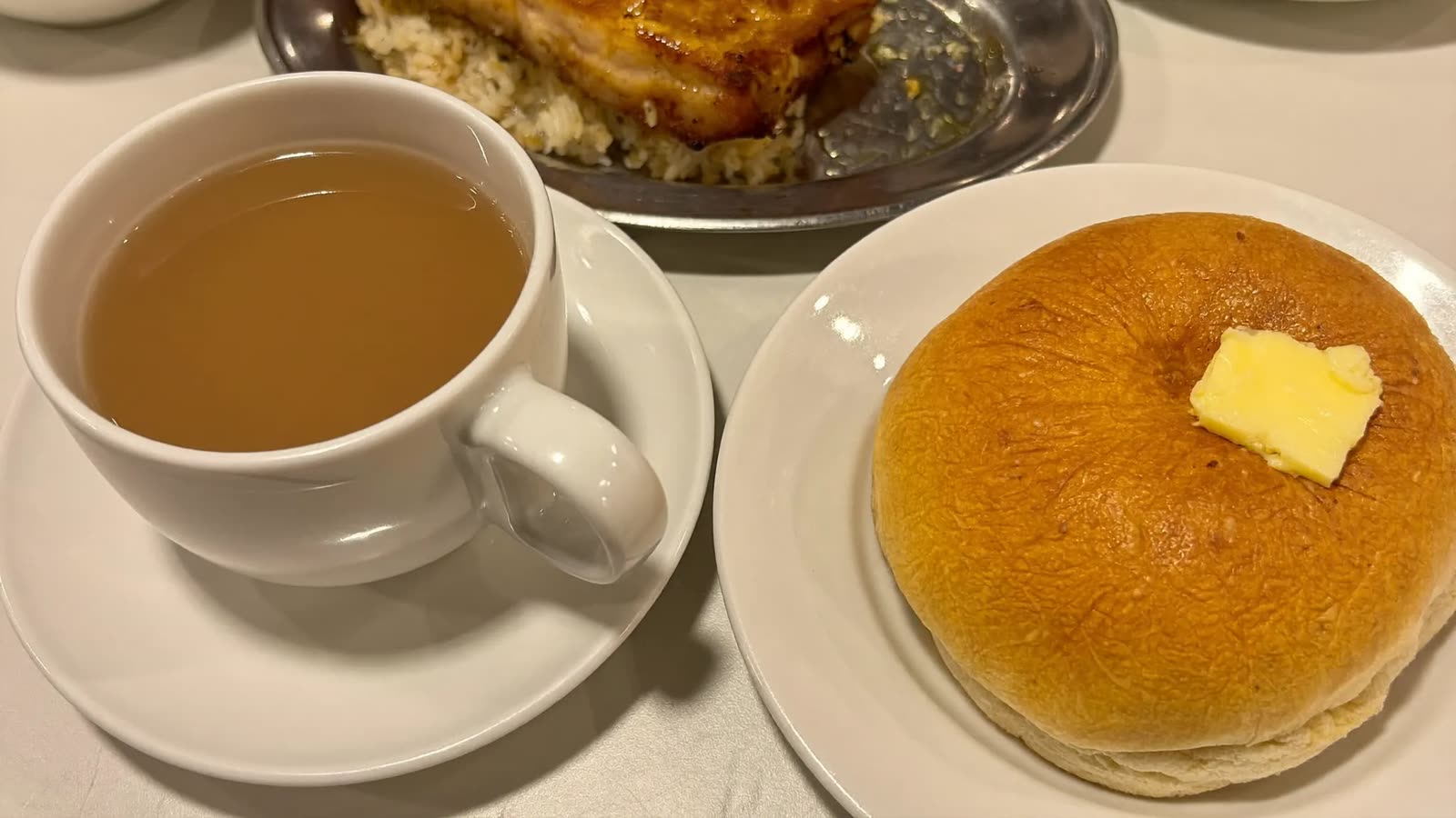Hong Kong milk tea, a pineapple bun and baked rice on a cafe table in North York
