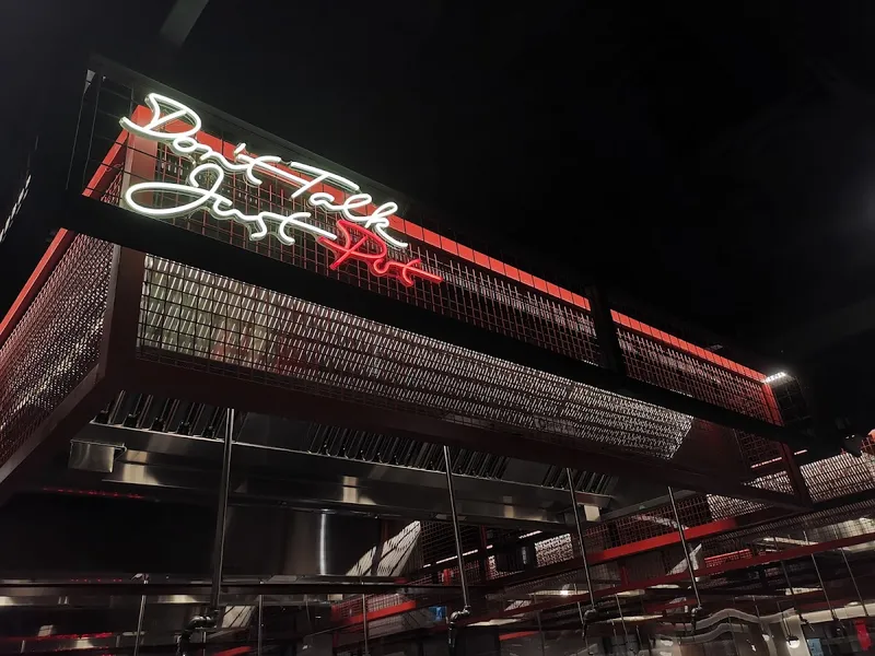 The Dolar Shop exterior at night with neon sign reading Don't Talk Just Pot