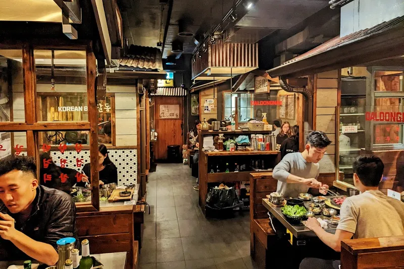Daldongnae Korean BBQ grill table with honeycomb pork belly and banchan